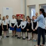 Uczniowie śpiewający na akademii szkolnej