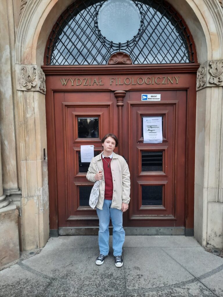 Uczeń stoi przed drzwiami Wydziału Filologicznego we Wrocławiu