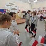 Harcerki rozdają flagi Polski