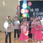 Uczniowie idą z kwiatami do nauczycieli i pracowników szkoły