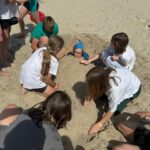 Dzieci bawiące się w piasku nad morzem.