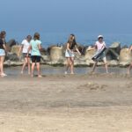Uczniowie bawią się na brzegu morza, spacer w morzu.