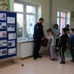 Policjant rozdaje uczniom upominki