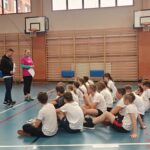 Uczniowie wykonują zadania gimnastyczne w ramach udziału w Niebieskich Igrzyskach - tor przeszkód.